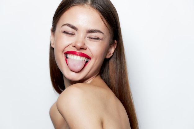 Jolie femme épaules nues montre la langue les yeux fermés sourire les traitements de spa