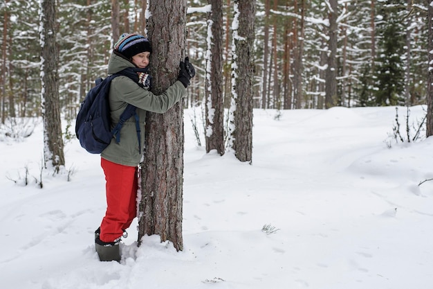 Jolie femme étreignant un arbre dans la forêt Le concept de conservation de la nature