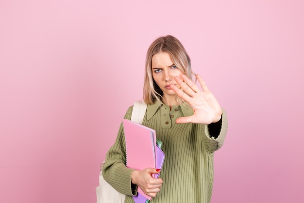 Jolie femme européenne en pull décontracté sur mur rose