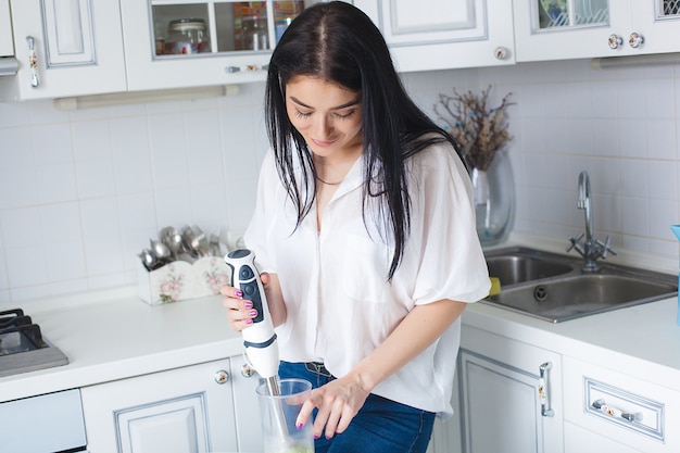 Jolie femme faisant un smoothie à l'intérieur