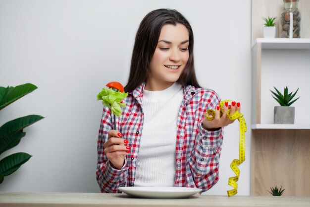 Jolie femme fait un choix entre des aliments sains et nocifs