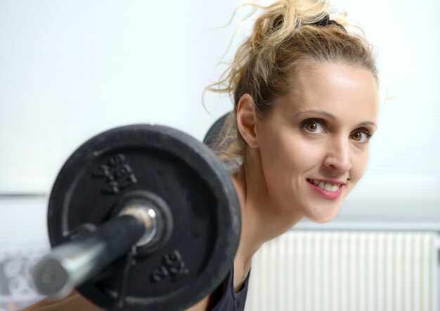 Jolie femme fitness soulevant des haltères