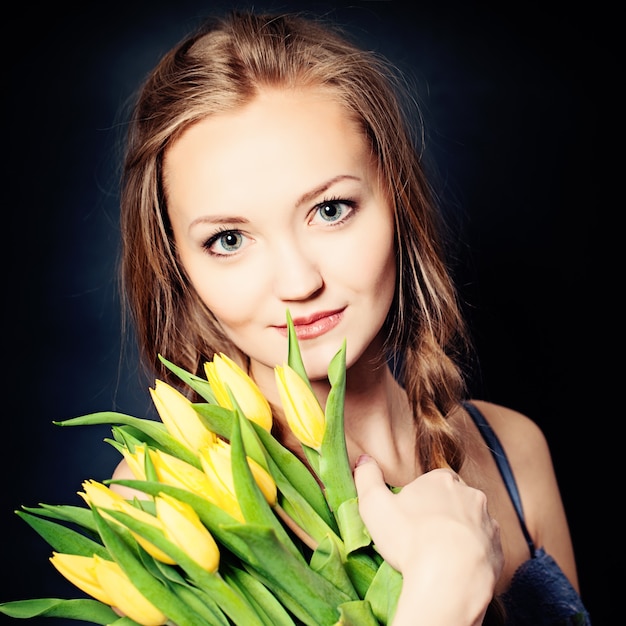 Jolie femme avec des fleurs de printemps jaunes