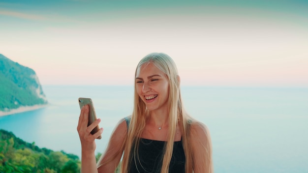 Photo jolie femme fournissant un appel vidéo avec vue sur les vacances sur l'océan dans les pays chauds