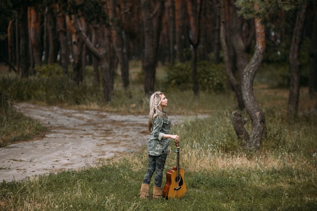 Jolie femme guitare nature look fashion concept. Unité avec la nature. Musique dans le coeur.