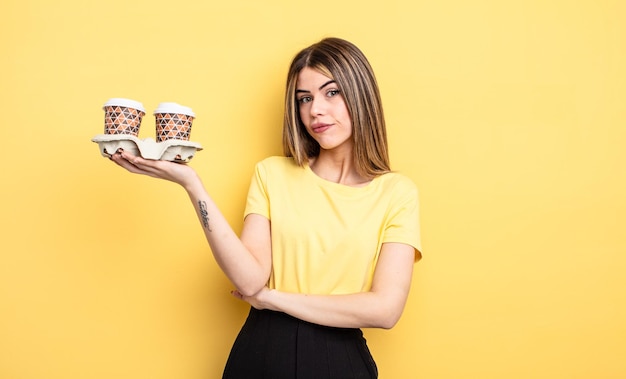 Jolie femme haussant les épaules se sentant confuse et incertaine concept de cafés à emporter