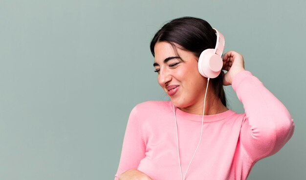 Jolie femme hismanique écoutant de la musique et dansant