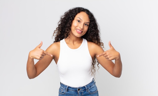 Jolie femme hispanique à l'air fière, arrogante, heureuse, surprise et satisfaite, se montrant elle-même, se sentant comme une gagnante