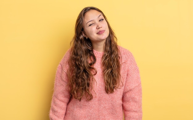 Jolie femme hispanique à l'air heureuse et amicale, souriante et vous regardant avec une attitude positive