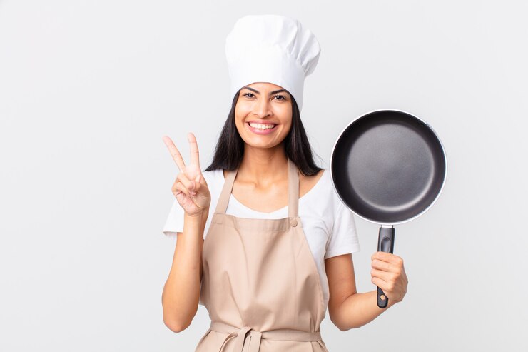 Photo jolie femme hispanique de chef tenant une casserole