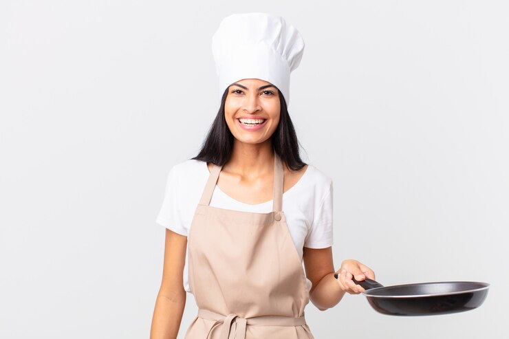 Photo jolie femme hispanique de chef tenant une casserole