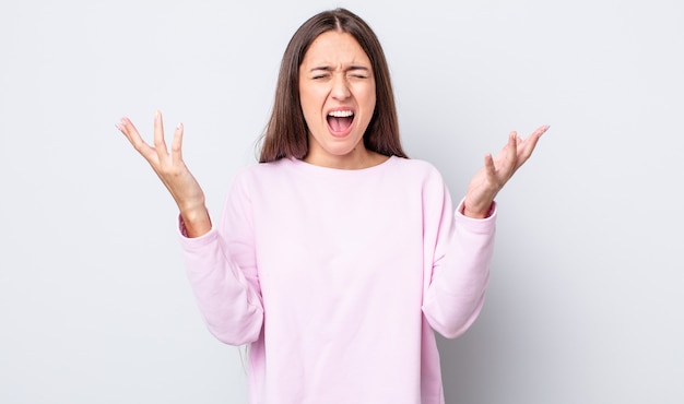 jolie femme hispanique criant furieusement, se sentant stressée et agacée avec les mains en l'air disant pourquoi moi