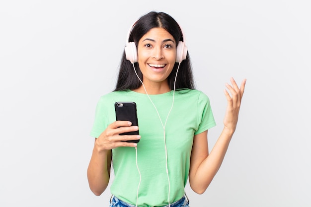 Jolie femme hispanique avec des écouteurs et un smarphone