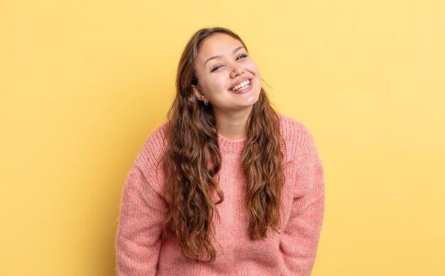 Jolie femme hispanique avec un grand sourire amical et insouciant, l'air positif, détendue et heureuse, effrayante