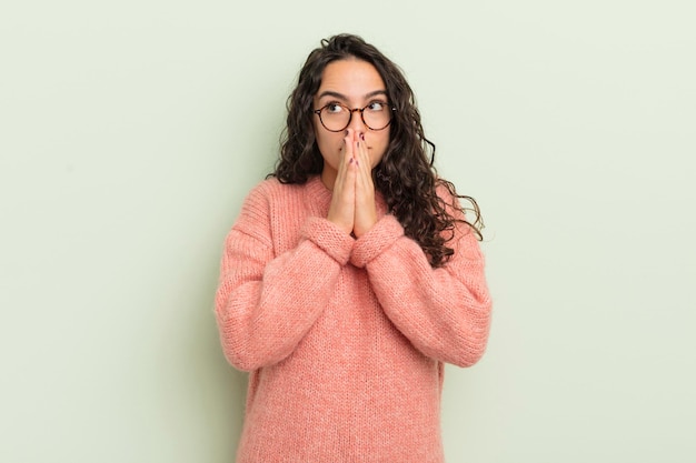 Jolie femme hispanique heureuse et excitée surprise et étonnée couvrant la bouche avec les mains riant avec une expression mignonne