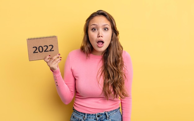 jolie femme hispanique qui a l'air très choquée ou surprise. notion de calendrier