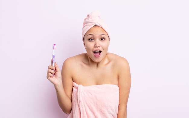 Jolie femme hispanique à la recherche d'un concept de brosse à dents très choqué ou surpris