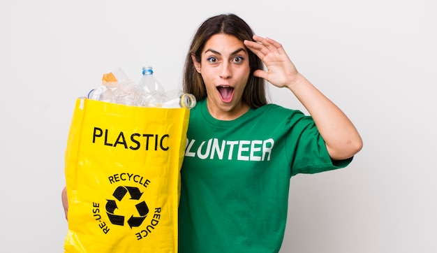 Jolie femme hispanique à la recherche d'un concept d'écologie étonné et surpris heureux