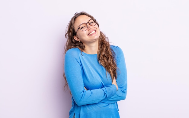 Jolie femme hispanique riant joyeusement avec les bras croisés, avec une pose détendue, positive et satisfaite