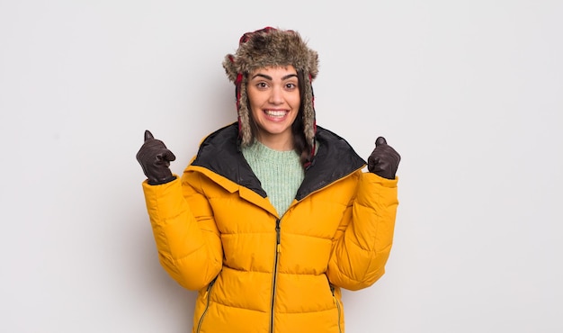 Jolie femme hispanique se sentant choquée en riant et célébrant le succès du concept de temps froid