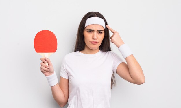 Jolie femme hispanique se sentant confuse et perplexe montrant que vous êtes un concept de ping-pong fou