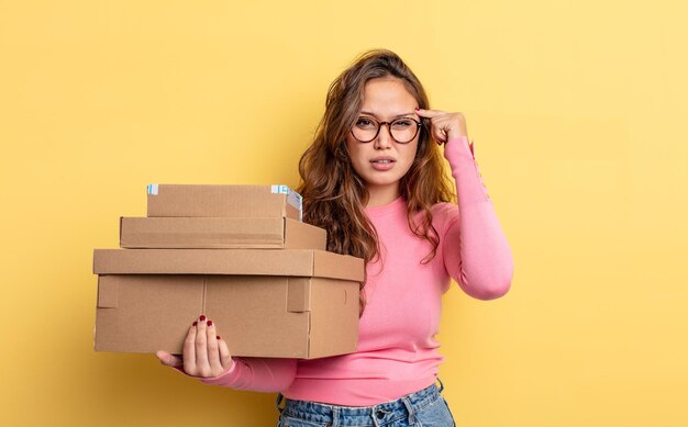 Jolie femme hispanique se sentant confuse et perplexe, montrant que vous êtes fou. concept de stockage