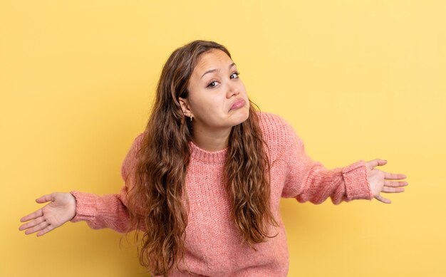 Jolie femme hispanique se sentant désemparée et confuse, n'ayant aucune idée, absolument perplexe avec un regard stupide ou stupide