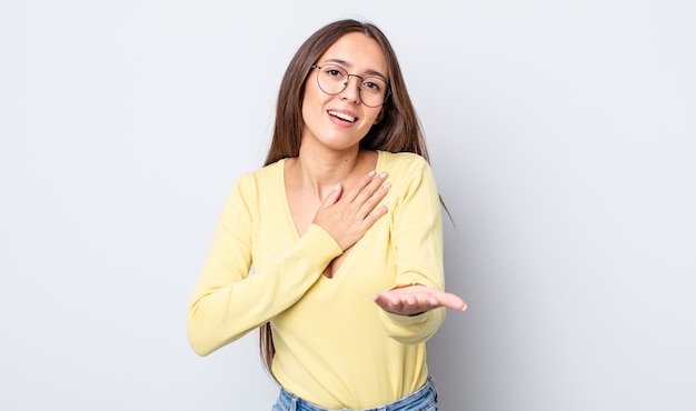 Jolie Femme Hispanique Se Sentant Heureuse Et Amoureuse, Souriante D'une Main à Côté Du Cœur Et De L'autre Tendue Vers L'avant