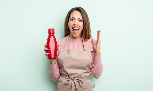 Jolie femme hispanique se sentant heureuse et étonnée de quelque chose d'incroyable. concept de ketchup