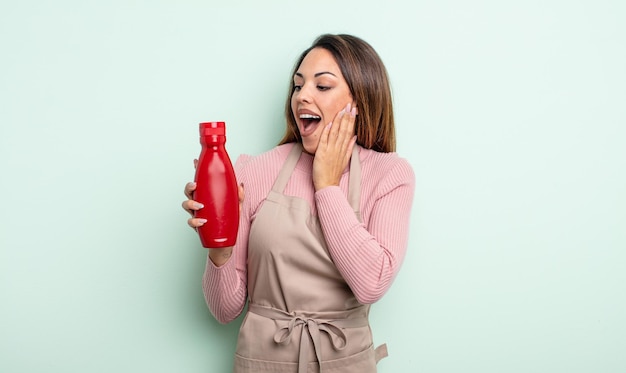 Jolie femme hispanique se sentant heureuse, excitée et surprise. concept de ketchup