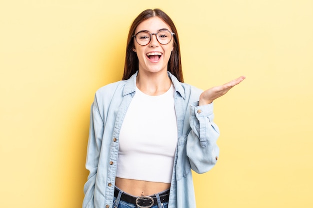 Jolie femme hispanique se sentant heureuse, surprise et joyeuse, souriante avec une attitude positive, réalisant une solution ou une idée