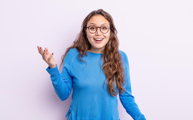 Jolie femme hispanique se sentant heureuse, surprise et joyeuse, souriante avec une attitude positive, réalisant une solution ou une idée