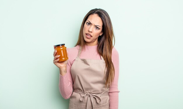 Jolie femme hispanique se sentant perplexe et confuse. concept de confiture de pêche