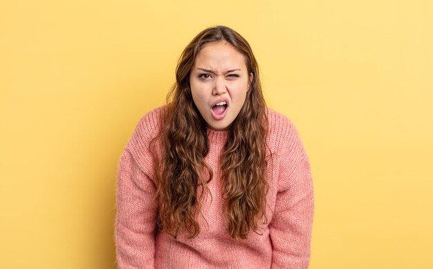 Jolie femme hispanique semblant choquée, en colère, agacée ou déçue, bouche bée et furieuse