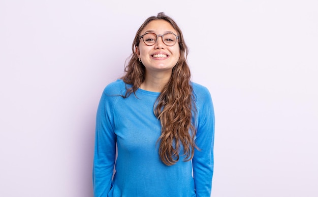 Jolie femme hispanique semblant heureuse et maladroite avec un large sourire amusant et loufoque et les yeux grands ouverts