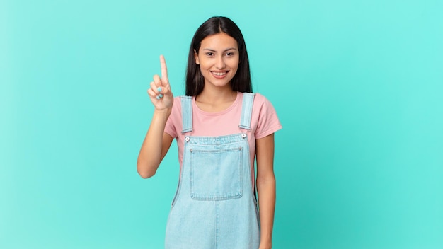 Jolie femme hispanique souriante et amicale montrant le numéro un