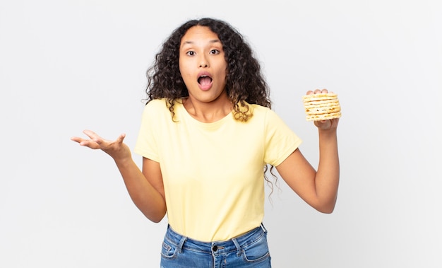 Jolie femme hispanique tenant des gâteaux de régime de riz