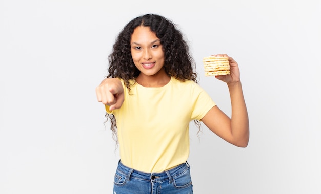 Jolie femme hispanique tenant des gâteaux de régime de riz