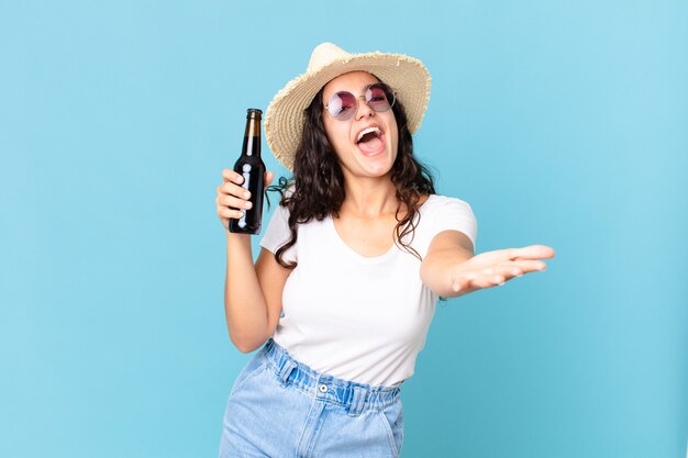 Jolie femme hispanique de voyageur avec une bouteille de bière