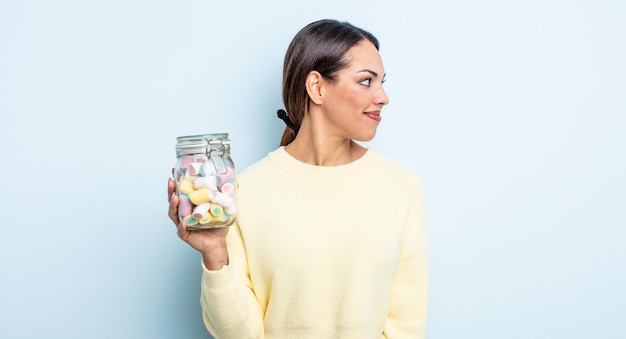 Jolie femme hispanique sur la vue de profil pensant, imaginant ou rêvassant. concept de bonbons à la gelée