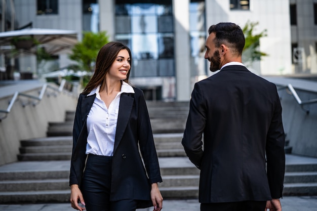 La jolie femme et l'homme en costume marchant dans le centre d'affaires