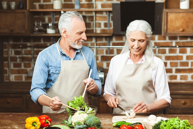 Jolie femme et homme cuisiner des aliments sains pour le dîner ensemble