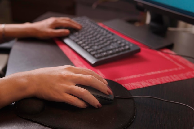 Jolie femme latine d'âge moyen utilisant la souris dans son espace de travail