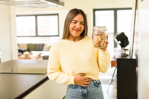 Jolie femme latine avec des bouteilles de biscuits faits maison