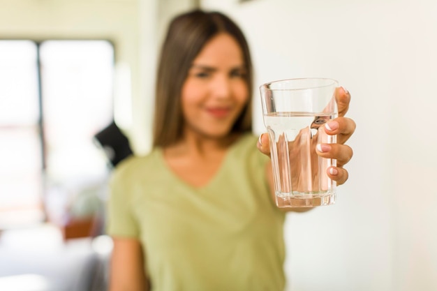 Jolie femme latine avec un verre d'eau à la maison