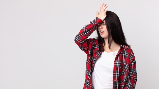 Jolie femme levant la paume vers le front pensant oups, après avoir fait une erreur stupide ou s'être souvenue, se sentir stupide