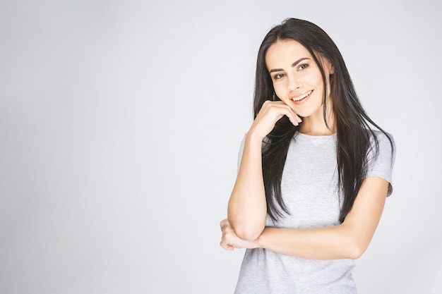 Jolie femme avec long brun étant très heureux de sourire. Isolé sur blanc.