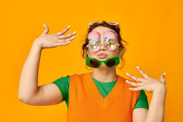 Jolie femme lunettes de soleil multicolores sur le visage posant grimace arrière-plans isolés inchangés