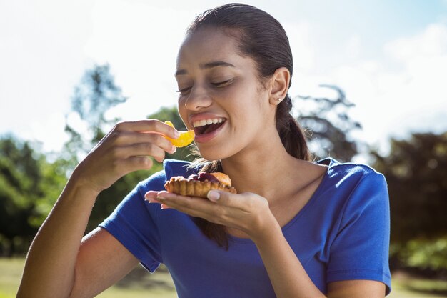 Jolie femme mangeant une pizza dans le parc