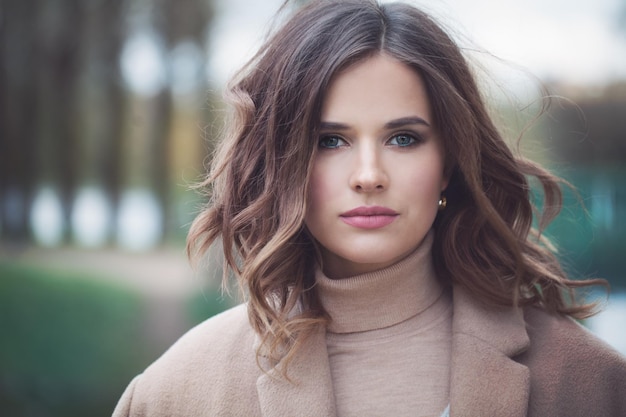 Jolie femme mannequin avec des cheveux bouclés. Jolie fille à l'extérieur